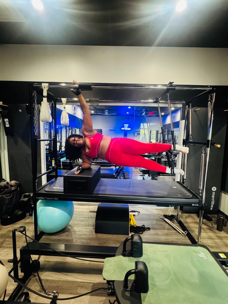 Side plank on the Cadillac Trapeze Table during a private session at Core Ambitions