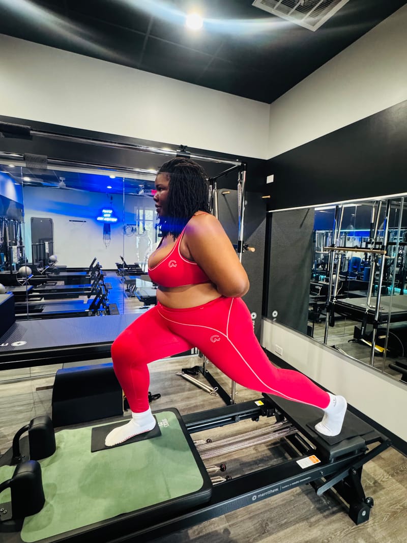 Standing lunge on the Reformer during private training at Core Ambitions