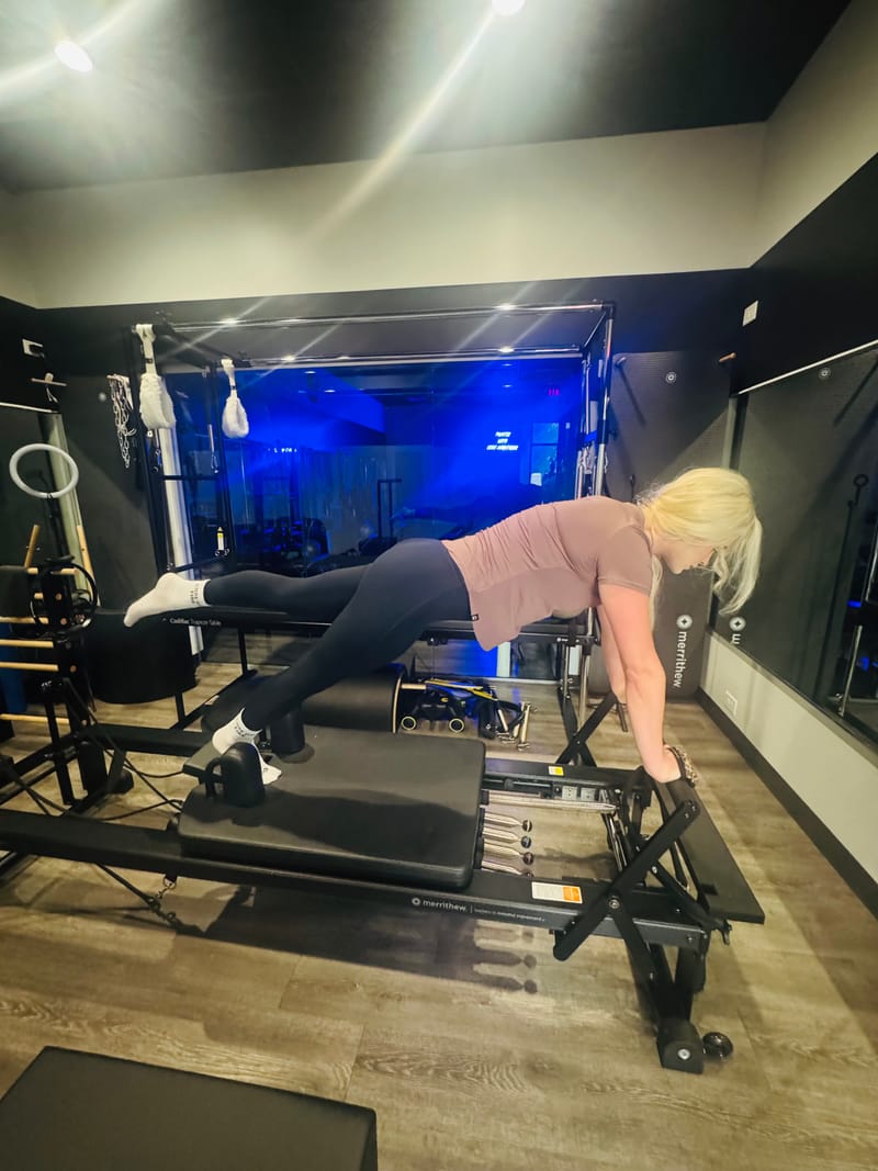 Plank with leg extension on the Reformer at Core Ambitions