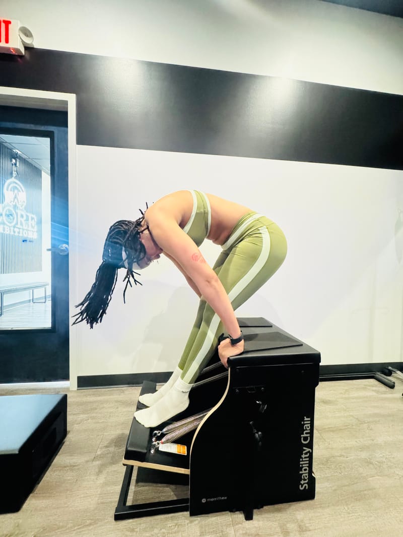 Standing roll-down on the Stability Chair during a private session at Core Ambitions